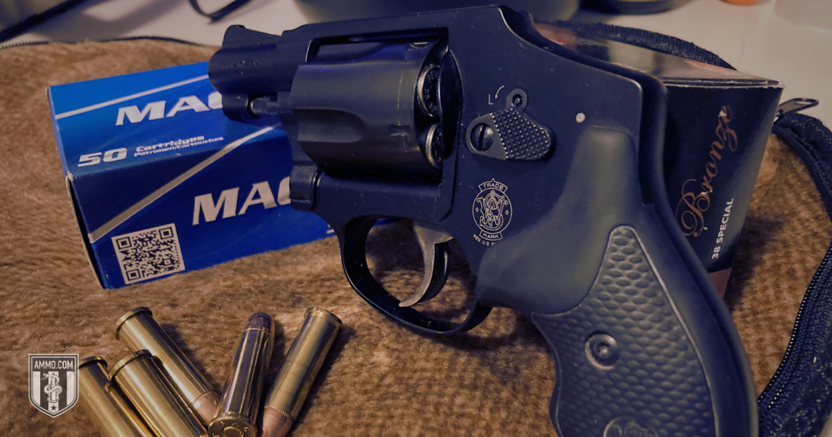 Snub-nose 38 Special revolver resting beside a box of 38 Special ammunition and loose cartridges